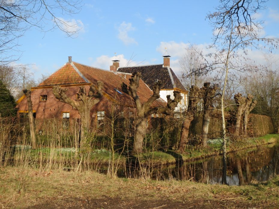 De pastorie van Eexta bezien van de achterkant; de pastorie is omringd door water en knotwilgen.